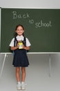 pleased schoolkid holding pen holder near