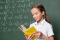 pleased schoolkid reading book near blurred