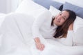 A pleased sleeping on the side young woman smiling softly in bed Royalty Free Stock Photo