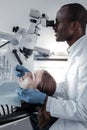 Pleased stomatologist examining teeth of his client