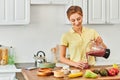 pleased woman pouring delicious smoothie from