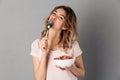 Pleased woman in t-shirt eating healthy food from plate