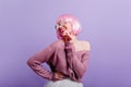 Pleased young girl in periwig and sunglasses having fun in studio. Photo of wonderful female model with pink hair