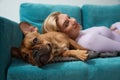 Pleased young woman and her pet resting in living room Royalty Free Stock Photo