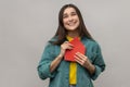 Pleased young woman holding envelope and reading letter, with happy expression, being touched. Royalty Free Stock Photo