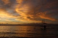 Pleasure boat against the backdrop of a cloudy golden sunset at sea. Royalty Free Stock Photo