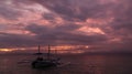 Pleasure boat on a background of cloudy purple sunset. Royalty Free Stock Photo