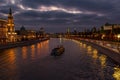 Pleasure boat floating on Moskva river in evening against dramatic cloudy sky. Landscape of the Moscow historical center Royalty Free Stock Photo