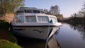 A pleasure boat moored up on a river in the Norfolk Broads