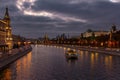 Pleasure boat on Moskva river near Moscow Kremlin in evening on a background of dramatic cloudy sky. City landscape Royalty Free Stock Photo