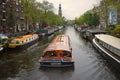 Pleasure boat on the Prinsengracht canal on a cloudy September day. Amsterdam, Netherlands