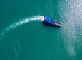 pleasure boat with tourists on Board floating in the sea, the trail with waves behind, top view from the drone Royalty Free Stock Photo