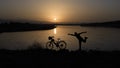 the pleasure of the cyclist coming to the edge of the pond with her bike and watching the sunrise