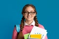 Pleasure of excellent test results. Girl with closed eyes holds notebooks and books