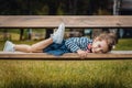 Pleasure little girl lying on bench in a park