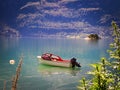 Pleasure motor boat moored to a buoy floats on calm waters of a fjord in Norway Royalty Free Stock Photo