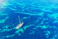 Pleasure yacht with sail stands on coral reef in blue transparent turquoise water sea caribbean. Concept travel. Aerial Royalty Free Stock Photo