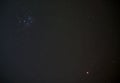 Pleiades also known as Seven Sisters open star cluster on winter night sky, bright red planet Mars in bottom right corner, long Royalty Free Stock Photo