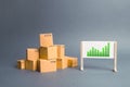 Plenty of cardboard boxes and whiteboard with green positive trend chart. rate growth of production of goods and products Royalty Free Stock Photo