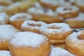 Plenty of donuts on the table sprinkled with powdered sugar