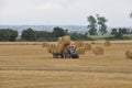 PLERIN, FRANCE -August 07 2018 :Tractor harvester roll straw at Plerin