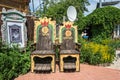 Two large wooden chairs in the courtyard of a private hotel 24.0