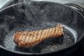 Pleurotus eryngii king oyster mushroom frying in iron cast pan creating beautiful steam. Royalty Free Stock Photo