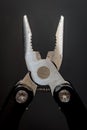 Pliars & x28;multitool& x29; with small signs of use on black background. Top view Royalty Free Stock Photo