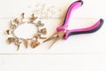 Pliers, bracelet, metal ring on a white wooden background. How to do yourself metal bracelet. Step