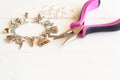 Pliers, bracelet, metal ring on a white wooden background. How to make yourself metal bracelet