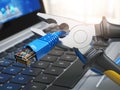 Pliers cutting lan network computer cable over laptop keyboard. Royalty Free Stock Photo