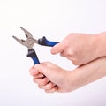 Pliers in the hand of a girl. Symbol of hard work, feminism and labor day. Isolate on white background Royalty Free Stock Photo