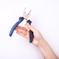 Pliers in the hand of a girl. Symbol of hard work, feminism and labor day. Isolate on white background Royalty Free Stock Photo