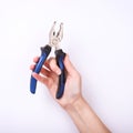 Pliers in the hand of a girl. Symbol of hard work, feminism and labor day. Isolate on white background Royalty Free Stock Photo