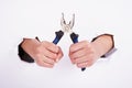 Pliers in the hand of a girl. Symbol of hard work, feminism and labor day. Isolate on white background Royalty Free Stock Photo