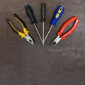 Pliers pliers with plastic bright pens protection set of screwdrivers on a dark brown background with copy spase base design