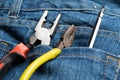 Pliers and screwdriver on bag jean background Royalty Free Stock Photo