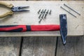 Pliers, screws, hammer, nails - on a bar and wooden unplaned boards. Hand tools for building Royalty Free Stock Photo