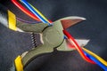 Pliers tool cutting electric wire closeup on a black background Royalty Free Stock Photo