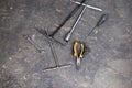 Pliers and tools for disassembling motorcycles and bicycles. Of a motor mechanic stained with oil on the cement floor in a repair