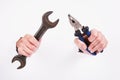 Pliers and wrench in the hand of a girl. Symbol of hard work, feminism and labor day. Isolate on white background Royalty Free Stock Photo