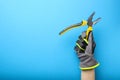 Pliers. Yellow and black pliers in the hand of an electrician on a blue monochrome background. Repair and installation Royalty Free Stock Photo