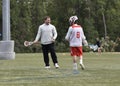 PLL, professional lacrosse player, Matt Rambo, teaching a young lacrosse player at a clinic. Royalty Free Stock Photo