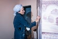 Woman artist working on wall painting, half-height plan.