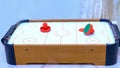 The plot shot of an air hockey game on a table Portable table hockey includes plastic hockey blades, a mini puck and