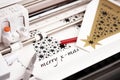 plotting machine makes large christmas stickers with star symbols and lettering from black adhesive vinyl film.