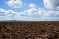 Plough plowed brown clay field blue sky horizon