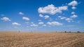 Ploughed cultivated ground, field and cloudy blue sky