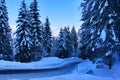 Slippery country road in snowy forest of mountainous region