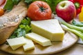 PloughmanÃ¢â¬â¢s lunch horizontal showing crusty French bread stick cheese tomato and apple. Royalty Free Stock Photo